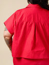 Person wearing a red shirt with a beige background