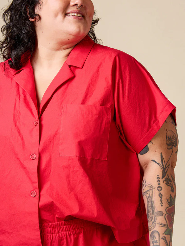 Person wearing a red shirt with a beige background