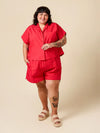 Person wearing a red outfit on a beige background