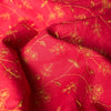 Elegant deep red linen fabric with dark golden floral embroidery, perfect for sophisticated projects.