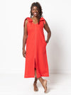 Woman wearing a red dress made using a style arc Esther woven dress sewing pattern with bow straps on a white background