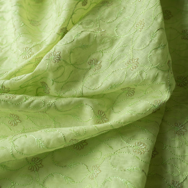 High-end vivid green linen fabric with subtle floral embroidery for luxury creations