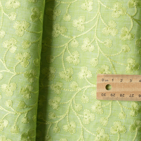 legant Sunny Lime Embroidered linen fabric with a chambray texture and green vine embroidery, ideal for sophisticated creations.