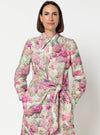 Woman wearing a floral dress made using Avon Woven Shirt and Dress sewing patternagainst a plain background