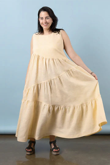 Woman wearing a yellow dress against made using Azure Dress, Skirt, and Top sewing pattern a light blue background