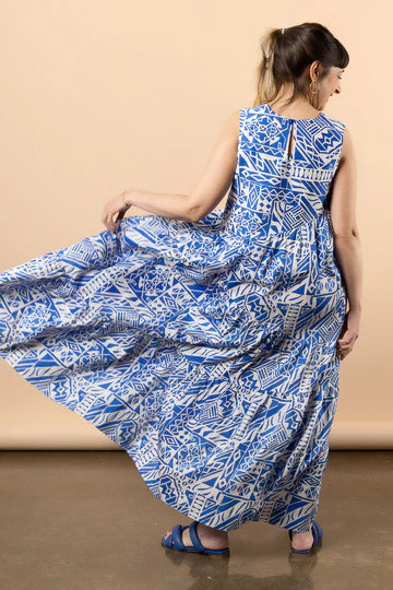 Woman wearing a blue and white patterned dress made using Azure Dress, Skirt, and Top sewing pattern against a beige background