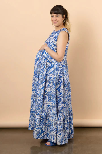 Woman wearing a blue patterned dressmade using Azure Dress, Skirt, and Top sewing patternagainst a beige background