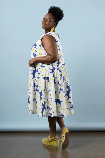 Woman wearing a floral dress made using Azure Dress, Skirt, and Top sewing pattern with a blue background