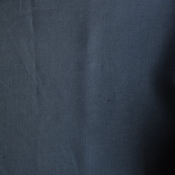 Close-up of darknavy blue linen fabric with folds
