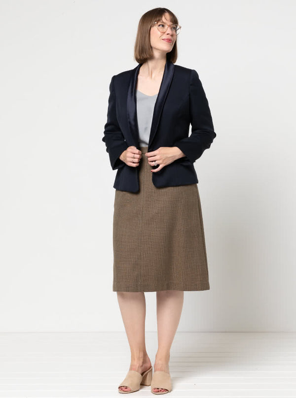 Woman wearing a navy blazer made using the Bronnie Tuxedo Jacket Sewing patternand brown skirt against a white background