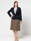 Woman wearing a navyJacket with contrast shawl collar and pocket flap made using the Bronnie Tuxedo Jacket Sewing pattern and brown skirt against a white background