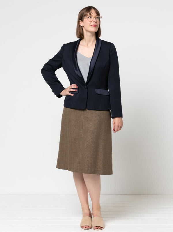 Woman wearing a navyJacket with contrast shawl collar and pocket flap made using the Bronnie Tuxedo Jacket Sewing pattern and brown skirt against a white background