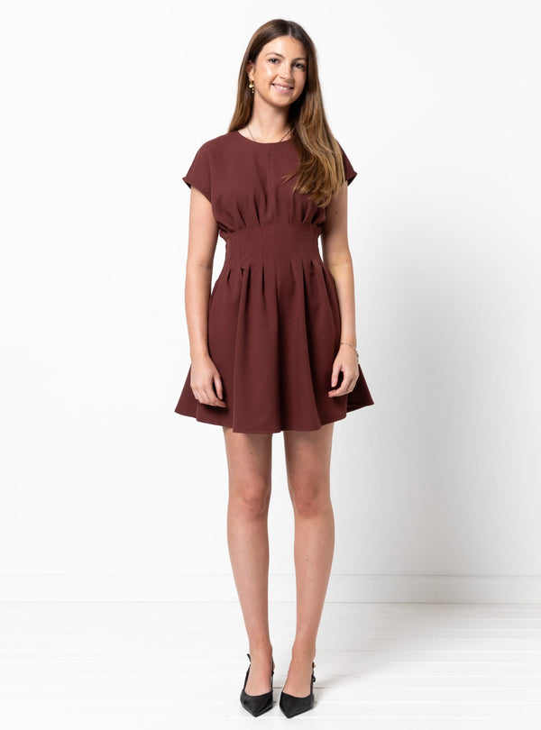 Woman wearing a brown dress made using Bronte Woven Dress sewing pattern on a white background
