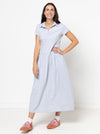 Woman wearing a light blue Carter Dress made using StyleArc pattern with tee bodice and mid-calf linen skirt with a white background