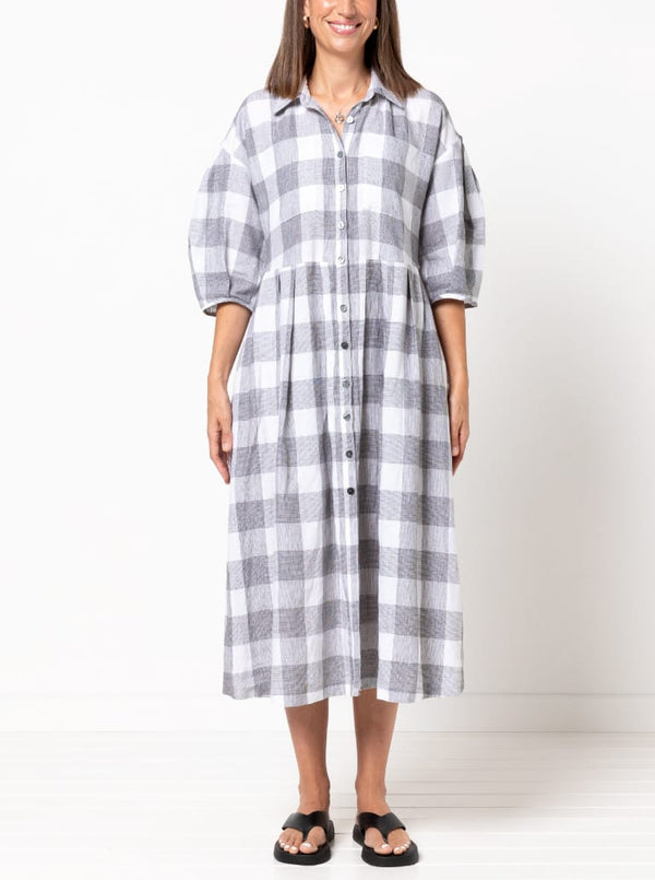 front view of Emerald Woven Shirt Dress sewing pattern featuring a waisted fit, irregular tucked skirt, shirt collar, optional sleeves or sleeveless style, and inseam pockets