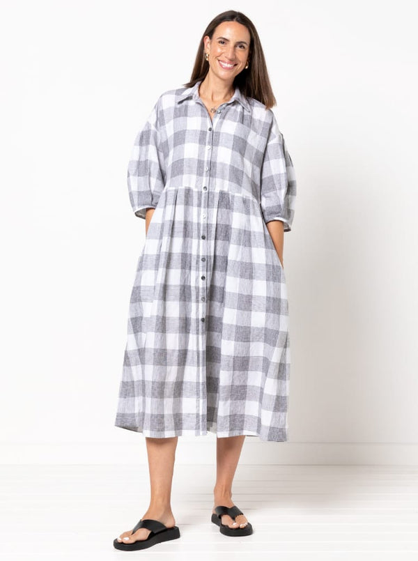 front view of Emerald Woven Shirt Dress sewing pattern featuring a waisted fit, irregular tucked skirt, shirt collar, optional sleeves or sleeveless style, and inseam pockets