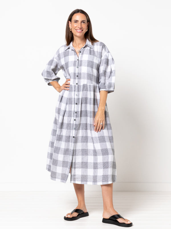 front view of Emerald Woven Shirt Dress sewing pattern featuring a waisted fit, irregular tucked skirt, shirt collar, optional sleeves or sleeveless style, and inseam pockets