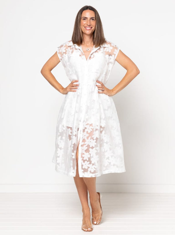 front view of Emerald Woven Shirt Dress sewing pattern featuring a waisted fit, irregular tucked skirt, shirt collar, optional sleeves or sleeveless style, and inseam pockets