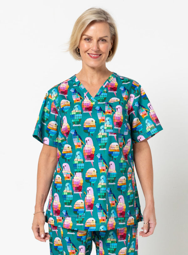Woman wearing a colorful scrub top with a pattern of ice cream cones on a white background