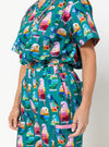 Person wearing a colorful parrot patterned dress on a white background