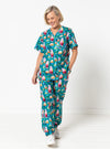 Woman wearing a colorful scrub set with a pattern on a white background