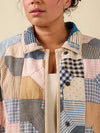 Person wearing a patchwork jacket with various patterns and colors.
