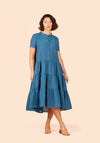 Woman wearing a blue tiered Poppy Dress on a beige background