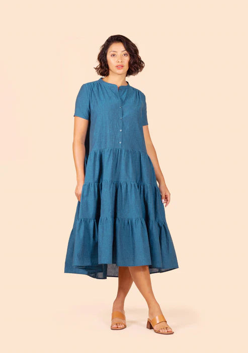 Woman wearing a blue tiered Poppy Dress on a beige background