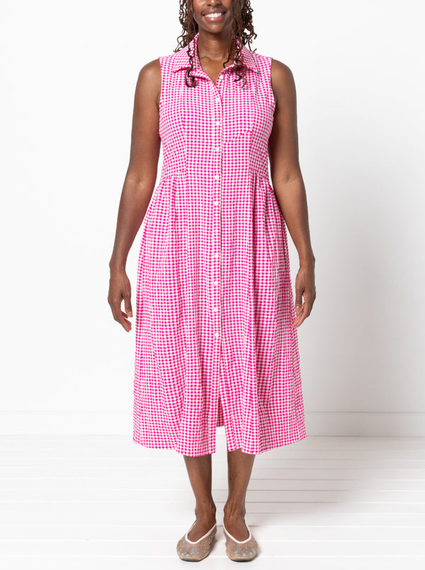 Woman wearing a pink checkered dress made from the Hampton Woven Dress Sewing Pattern against a white background