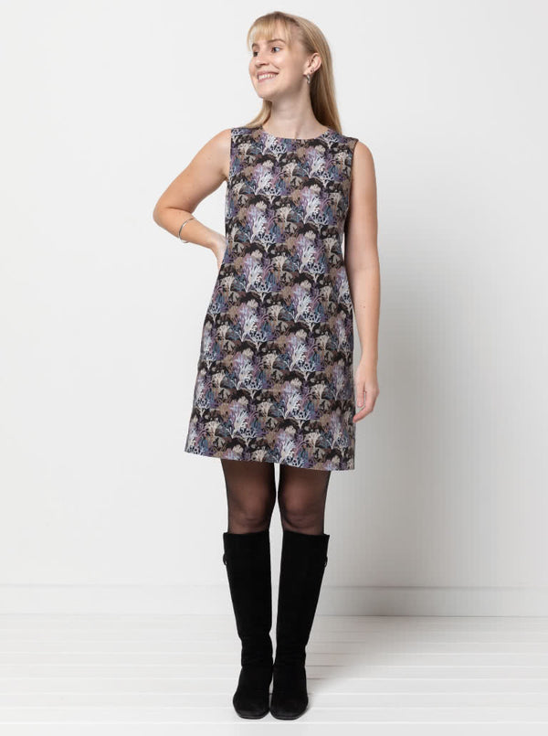 June Sheath Dress sewing pattern, featuring a sleeveless slip-on design with a very slight A-line shape and inseam pockets, suitable for crepe, linen, rayon, cotton, and brocade fabrics.