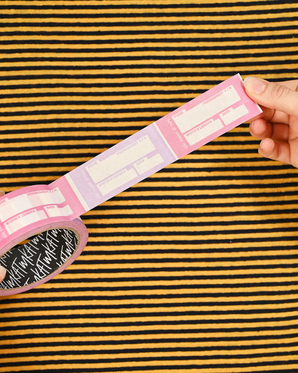 Hand holding a pink and white striped object against a yellow and black striped background