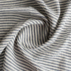 Close-up of Marine Stripe 100% Linen Fabric with alternating dark and light stripes.