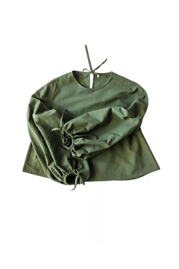 Green blouse with balloon sleeves on a white background The Edie Sewing Pattern by Merchant & Mills – balloon sleeve top and dress pattern in linen or cotton