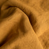 Close-up of Mustard extra wide 100% linen fabric with visible texture