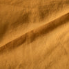 Close-up of Mustard extra wide 100% linen fabric with a textured pattern