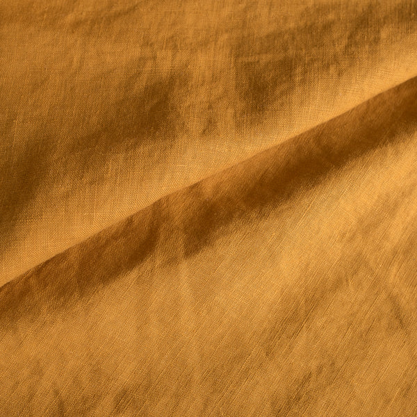 Close-up of Mustard extra wide 100% linen fabric with a textured pattern