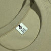 Close-up of a bgreen fabric with a label featuring a paw print design and text.