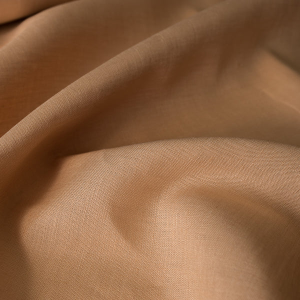 Nutmeg-colored 100% linen fabric with a fine, close weave, smooth finish, and soft drape, suitable for various dressmaking applications.