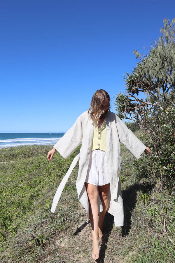 Pipit Vest Sewing Pattern - Reversible Oversized Vest in Two Lengths. Image of A woman wearing pipit vest made oflinen fabric in the beach side