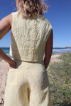 Pipit Vest Sewing Pattern - Reversible Oversized Vest in Two Lengths. Image of A woman wearing pipit vest made of yellow colour linen fabric in the beach side