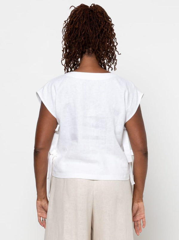 Person wearing a white top with sheer sleeves made using Rumi Top Sewing Pattern on a plain background