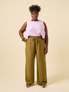 Woman wearing a light pink sleeveless top and green wide-leg pants made using Sepia Pants and Shorts sewing pattern against a beige background