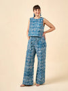 Woman wearing a blue geometric patterned outfit made using Sepia Pants and Shorts sewing pattern on a beige background