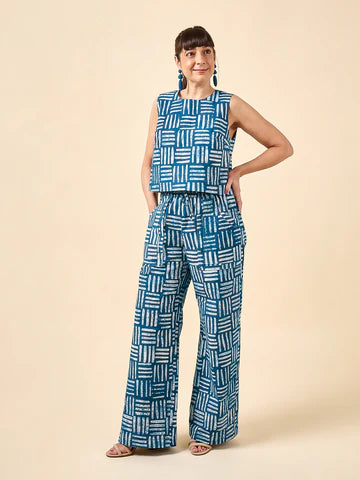 Woman wearing a blue geometric patterned outfit made using Sepia Pants and Shorts sewing pattern on a beige background
