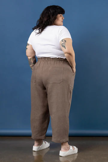 Person wearing a white t-shirt and brown pants made using Sepia Pants and Shorts sewing pattern against a blue background
