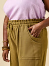 Person wearing mustard yellow pants made using Sepia Pants and Shorts sewing pattern with a plain background