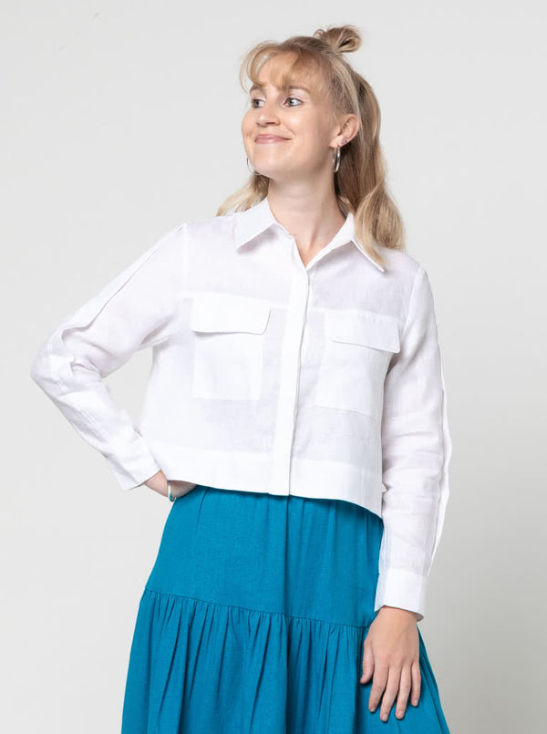 lady wearing white jacket made using Smith Woven Jacket with buttoned fly front, square shape, full-length sleeves with tabs, front pockets, and back pleat, made from linen fabric.