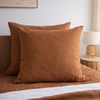 Tobacco brown European linen pillowcases on a bed in a bedroom setting