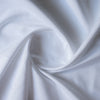 Close-up of Close-up of White Twill linen–cotton fabric showing subtle diagonal twill texture in pure white with folds