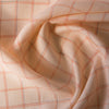 Subtle check Peach Puff 100% linen fabric with variegated thread, ideal for creating elegant and versatile garments